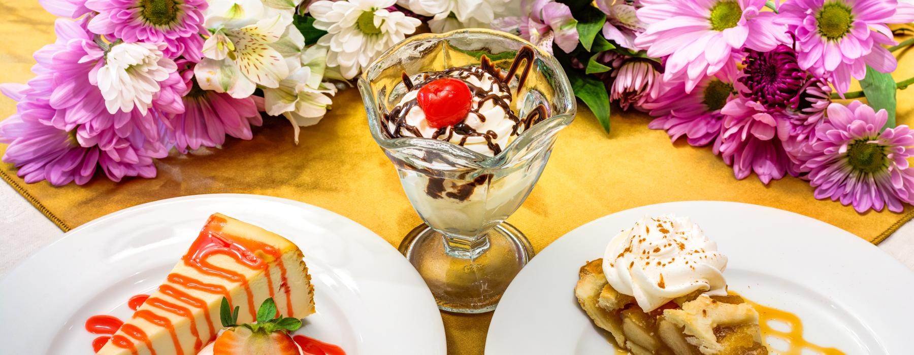 a table with plates of desserts and a glass of water